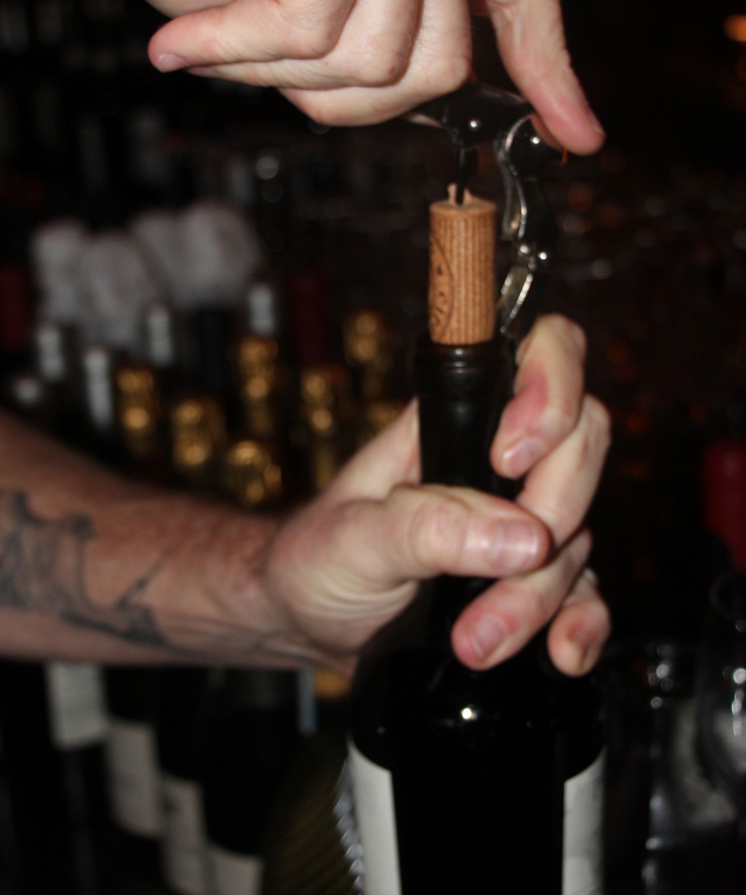Server opening a wine bottle